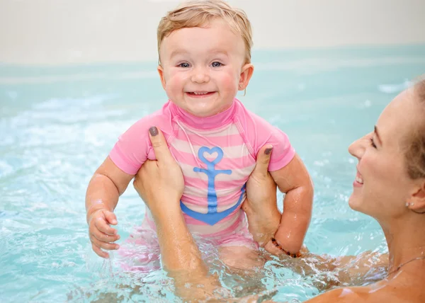 Group portrait of white Caucasian mother and baby daughter playing in water diving in swimming pool inside, looking in camera, training to swim, healthy active lifestyle — Stock Photo, Image