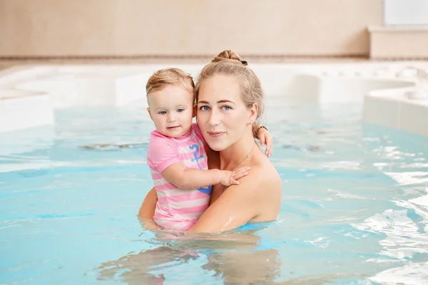 Portrait de groupe de mère blanche caucasienne et bébé fille jouant dans l'eau dans la piscine à l'intérieur, regardant à la caméra, s'entraînant à nager, mode de vie sain et actif — Photo