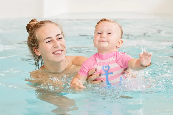 Grupp porträtt av vit kaukasiska mor och baby dotter spelar i vatten dykning i SIM bassäng inne, utbildning för att simma, hälsosam aktiv livsstil — Stockfoto