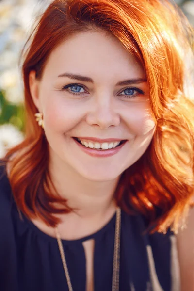 Retrato de close-up de mulher branca branca de meia idade sorridente com cabelo encaracolado ondulado vermelho em vestido preto olhando na câmera fora no jardim do parque, conceito de estilo de vida de moda de beleza — Fotografia de Stock