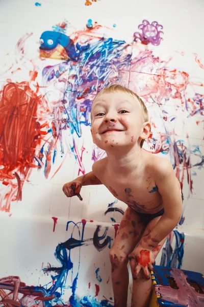 Retrato de bonito adorável branco caucasiano menino brincando e pintura com tintas na parede no banheiro se divertindo, conceito de infância estilo de vida — Fotografia de Stock