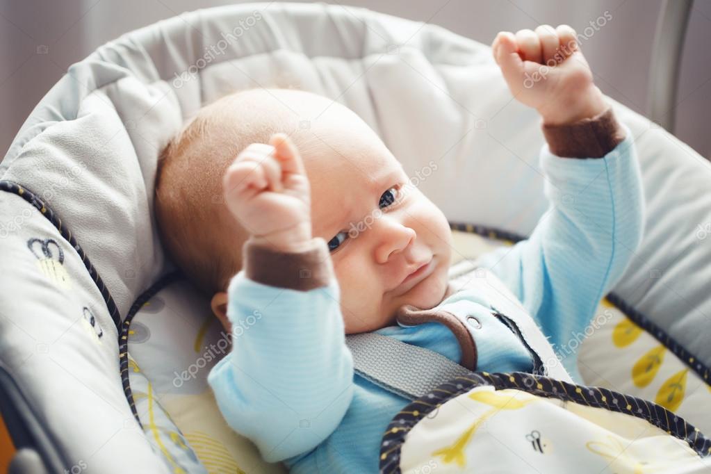 かわいいかわいい面白い白白人金髪の小さな赤ちゃんの男の子ブルー グレー新生児の縦目応援 ライフ スタイルを彼の手でカメラで見ている青い服で率直な現実 ストック写真 C Anoushkatoronto