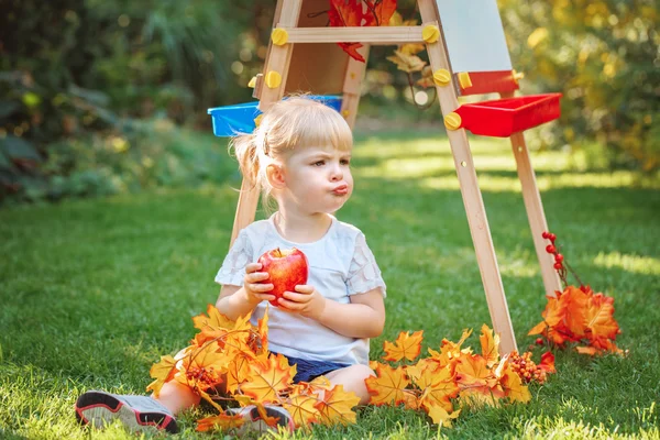 Vita kaukasiska småbarn barn kid flicka sitter utanför i sommar höst park genom att rita staffli äta äpple tittar bort, spela studerar lärande, tillbaka till skolan — Stockfoto