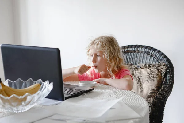 Młoda Dziewczyna Jedzenie Ogląda Kreskówki Laptopie Dziecko Cyfrowym Gadżetem Podczas — Zdjęcie stockowe