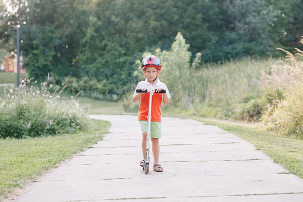 กชายผ วขาวท ความส ขในหมวกก ตเตอร บนถนนในสวนสาธารณะในว นฤด ฬาก จกรรมกลางแจ าหร — ภาพถ่ายสต็อก