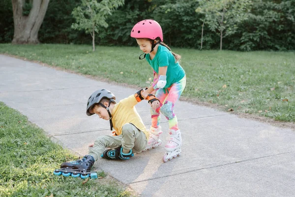 Chica Ayudando Niño Ponerse Pie Patines Después Caer Amigos Caucásicos — Foto de Stock