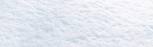 Beyaz kar kış dokusu. Noel tatili geçmişi. Mevsimlik beyaz kar rengi arka plan duvar kağıdı. Açık havada güneşli bir günde kıtır kıtır parlayan kar. Web başlığı. 