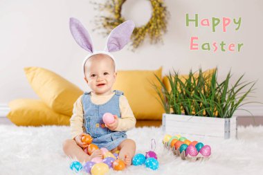 Mutlu Paskalyalar. Tatil kartını mesajla selamlıyorum. Pofuduk beyaz halının üzerinde oturan mor tavşan kulaklı beyaz bir kız bebek. Paskalya yumurtalarıyla oynayan çocuk Hıristiyan bayramını kutluyor.