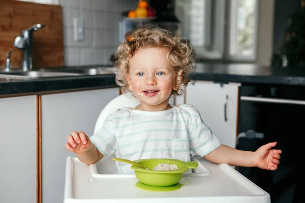 Söt Vit Lockig Pojke Som Sitter Barnstol Och Äter Flingpuré — Stockfoto