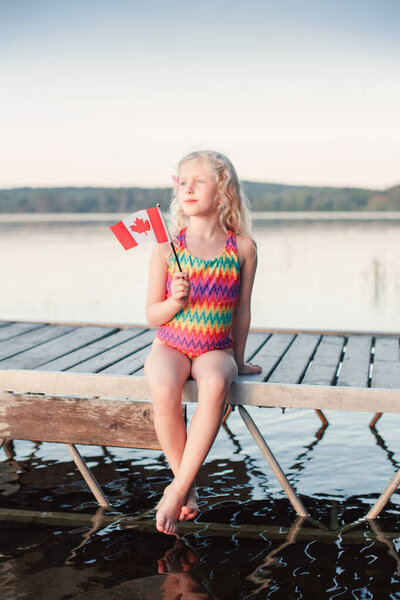 Happy Caucasian Girl Sitting Dock Pier Lake Waving Canadian Flag Stock Picture