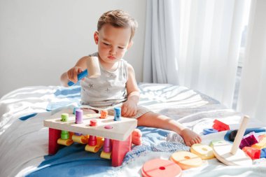 Evde çok renkli oyuncaklarla oynayan tatlı bir bebek tezgahı yumrukluyor. Öğrenmeyi say. Erken yaşta Montessori eğitimi. Çocuklar, anaokulu öğrencileri için beyin geliştirme aktivitesi düzenliyor. 