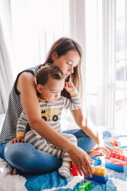 Anne ve bebek evde oyuncak istifleme oyunu oynuyorlar. Erken yaşta Montessori eğitimi. Çocuklar beyin ve iyi motor beceriler geliştirir. Anaokulu öğrencileri için mantıksal aktivite.  