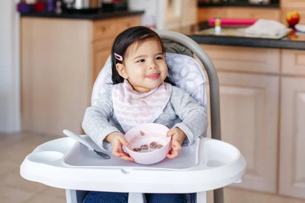 可爱的亚洲中国小女孩坐在高高的椅子上 用勺子喝汤 儿童的健康饮食 托德勒独自在家厨房里吃饭 真真正正的一刻 — 图库照片