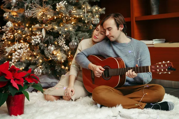 Άνδρας Και Γυναίκα Γιορτάζουν Μαζί Χριστούγεννα Πρωτοχρονιά Άντρας Παίζει Κιθάρα — Φωτογραφία Αρχείου