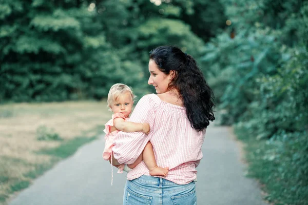 母の日の休日 幼い娘を抱いている若い白人の母親 夏の屋外で子供の赤ちゃんを受け入れるお母さん 幸せな本物の家族の子供時代のライフスタイル — ストック写真