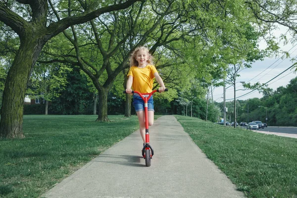 Χαριτωμένο Αστείο Καυκάσιο Κορίτσι Παιδί Κίτρινο Shirt Ιππασία Κόκκινο Σκούτερ — Φωτογραφία Αρχείου