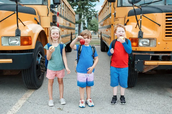 노란색 버스에서는 아이들 여학생들 사과를 건강에 간식으로 먹습니다 월에는 교육을 — 스톡 사진