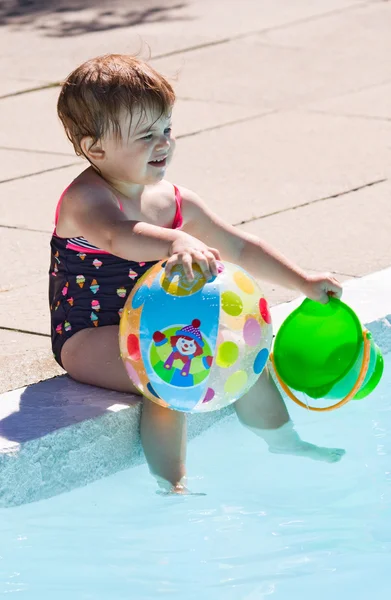 Baby playing in swimming pool water — Stock Photo, Image