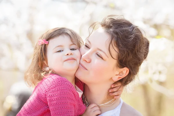 Portrait of mother and daughter kissing laughing — Stock Photo, Image