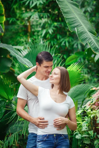 Man woman couple hugging among green trees plants — Stock Photo, Image