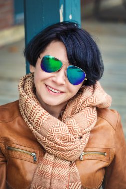 Orta yaşlı beyaz esmer kadın sunglasse sonbaharda dışında