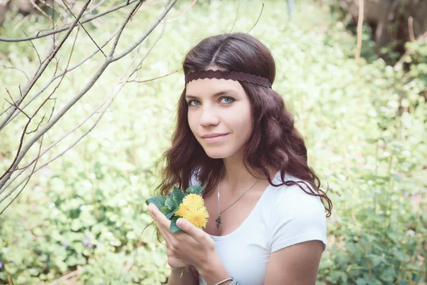 Portret van hippie meisje in bos met bloemen — Stockfoto