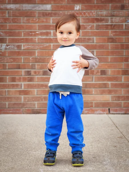 Toddler boy by brick wall laughing — Stock Photo, Image