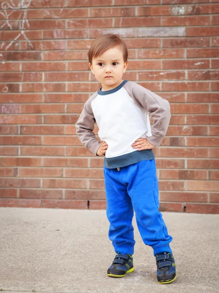 Toddler boy by brick wall laughing — Stock Photo, Image