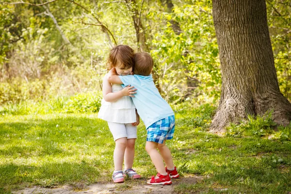 Två barn barn kramar kyssar Royaltyfria Stockfoton