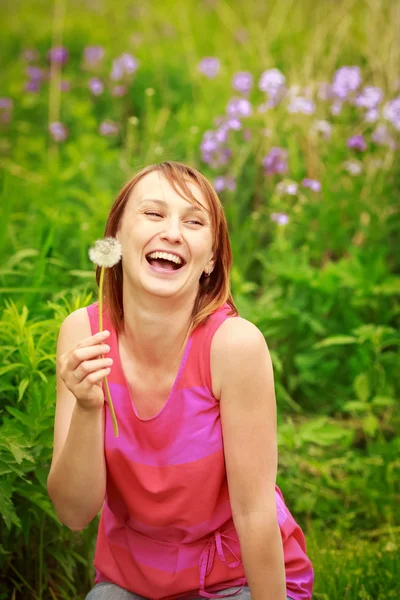 Chica joven soplando dientes de león — Foto de Stock