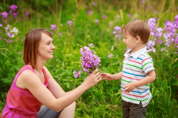 Мать и сын на цветочном поле летом — стоковое фото