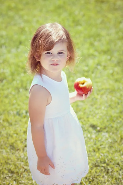 Retrato de niña en vestido blanco con manzana afuera —  Fotos de Stock