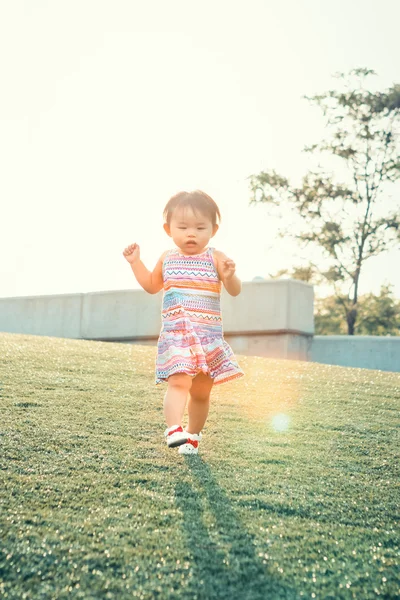 Asia cina gadis di padang rumput pada matahari terbenam — Stok Foto