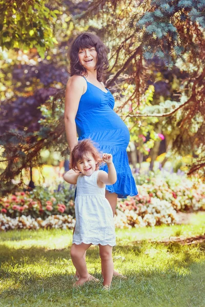 Porträt schwangere Mutter und Tochter umarmen sich beim Spielen — Stockfoto