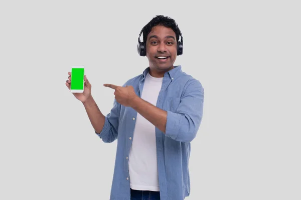 Індіанець слухає музику з телефонної пошти на ній. Пісню в мюзиклі. Людина вказувала на телефонний зелений екран. Відокремлені — стокове фото