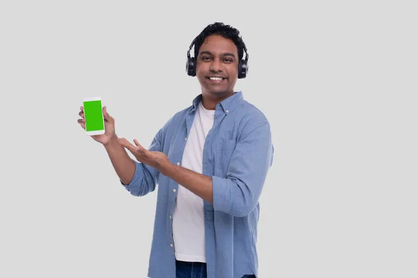 Indian Man Listening to Music from Phone Apontando para ele. Man Singing to the Music. Homem apontando para tela verde do telefone. Isolados — Fotografia de Stock