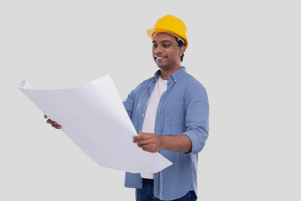 Construção Trabalhador Segurando Casa Plano em Mãos Assistindo a ele. Architect Holding Blueprints. Capacete duro amarelo. — Fotografia de Stock
