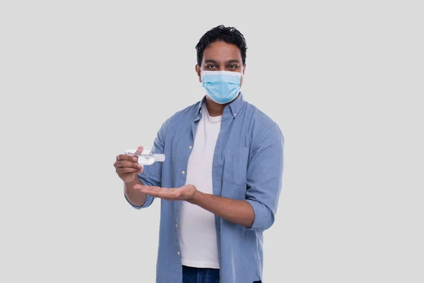 Indian Man bär medicinsk mask med hjälp av handdesinfektionsmedel. Man som använder händerna antiseptiska — Stockfoto