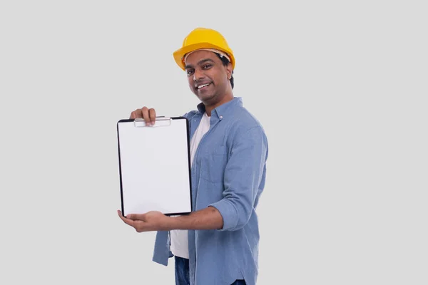 Trabalhador da construção mostrando Clipboard vestindo HardHat amarelo. Isolados — Fotografia de Stock