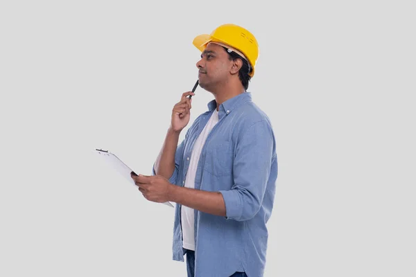 建筑工人手里拿着房屋计划 看着它 建筑师拿着蓝图 黄色硬头盔 — 图库照片
