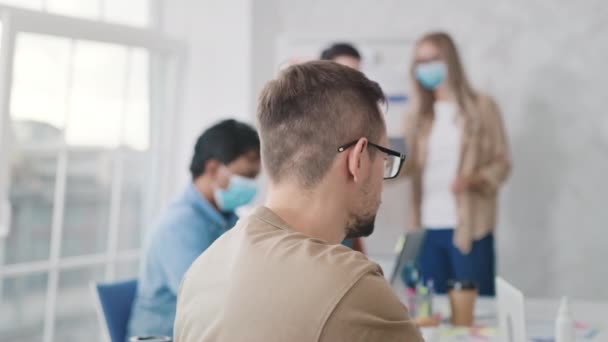 Man sätter på sig Medicinsk Mask i Creative Office. Medicinskt skydd på jobbet. Mannen bär medicinsk mask på kontoret. Hälsa, medicinsk, Corona Virus Concept. Skjuten på RED — Stockvideo