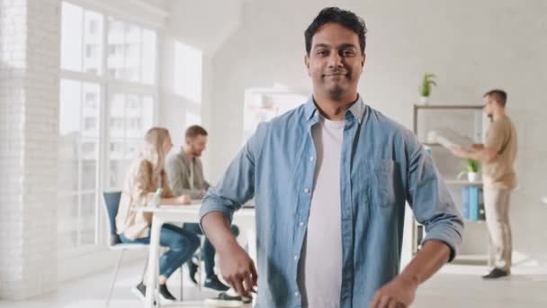 Indian Man stående händer korsade i Creative Office. Kontorsarbetsdag. Kreativa teamet jobbar. Hands Motion Skott på RED — Stockvideo