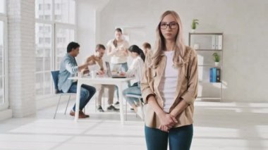 Yaratıcı Ofiste Şirin Utangaç Kız Gülümsüyor. Gözlük ayarlayan kız. Ofis işi günü. Ofiste takım çalışması. Kırmızıda Çekilen Kız Portresi