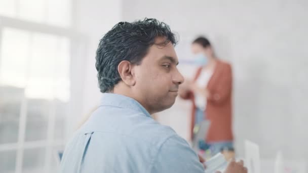 Indian Man sätter på Medical MAsk i Creative Office. Medicinskt skydd på jobbet. Mannen bär medicinsk mask på kontoret. Hälsa, medicinsk, Corona Virus Concept. Skjuten på RED — Stockvideo
