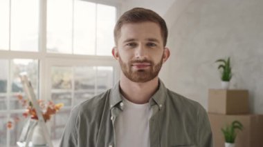 Yeni Evdeki İnsanın Video Portresi. Adam yeni eve taşındı. Evde gülümseyen bir adam. Kırmızı ışıkta.