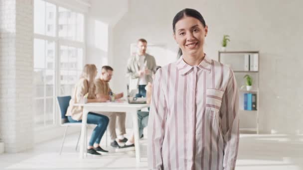 Flicka fräsning i Creative Office under arbetet. Kreativa kontorsarbetets dag. Video Porträtt av Girl Smilling på jobbet. Hands Motion Skott på RED — Stockvideo