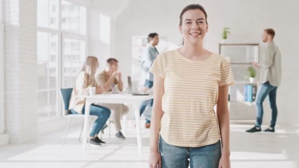 Girl Smilling in Creative Office During Work Showing Thumb Up dan Blinking with Eye. Hari Kerja Kreatif Kantor. Video Portrait of Girl Smilling at Work (dalam bahasa Inggris). Hands Motion Shot on RED — Stok Video