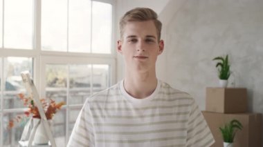 Yeni Evdeki İnsanın Video Portresi. Adam yeni eve taşındı. Evde gülümseyen bir adam. Kırmızı ışıkta.