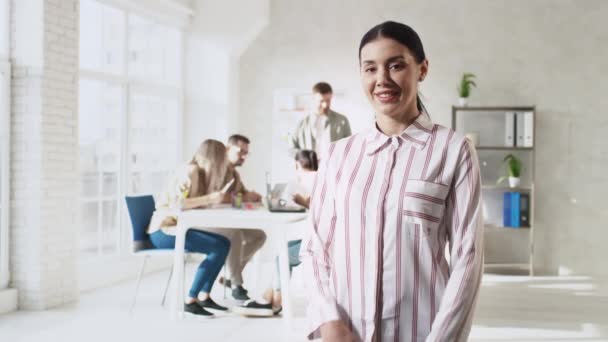 Girl Standing Hands SCross in Creative Office. Pracovní den v kanceláři. Tvůrčí tým pracuje. Ruční pohyb výstřel na RED — Stock video