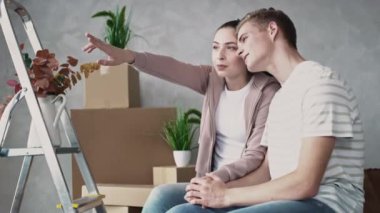 Pencereden dışarı bakan çift yeni Düz Kız Gösteriyor. Çift yeni bir eve taşındı. Güneşli bir günde bir çift taşınıyor. Eller Hareketi Görüntüsü Kırmızıda